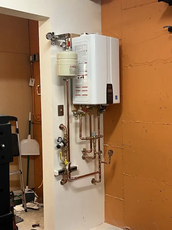 Plumbing technician inspecting water heater connections in Poughkeepsie